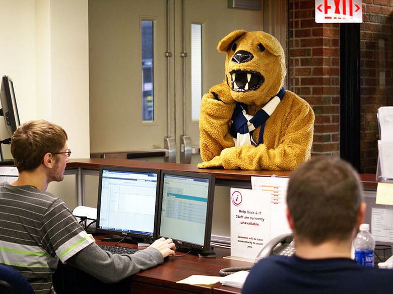 Two service desk consultants provide assistance to the Nittany Lion mascot.
